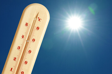Wall Mural - thermometer showing high temperature against sky with bright sun. extremely hot weather