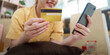 © Natee Meepian - Online Shopping. Young woman using smartphone and credit card for e-commerce purchase.