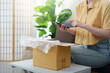 © Natee Meepian - Online Shopping. Unboxing a package at home with smartphone.