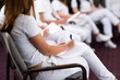 © .shock - Close up of a student holding a pen and writing notes in a notebook during a professional training and education session in a wellness and therapy course