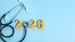 © Pcess609 - Stethoscope with golden numbers 2026 on a light blue background represents health planning, medical insurance coverage, wellness goals, family care, and budgeting for the new year with copy space.