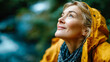 © Aliaksandra - Elderly woman in yellow raincoat looking up happily while enjoying a peaceful forest hike