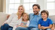 © BloomPix - Happy Family Relaxing on Sofa Together. A family of four, including parents and two young children, are sitting together on a sofa, smiling and looking at something off-camera, portraying a loving