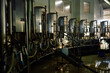 © TrueFrame Collective - Rotary milking parlor during the process of cleaning: floor is wet and equipment is covered with drops of water. Trash bag filled with garbage and containers with water seen on the background.