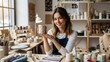 © Ahmad - A smiling female potter holds up a finished, handmade ceramic mug, showcasing her craftsmanship in a sunlit pottery studio.
