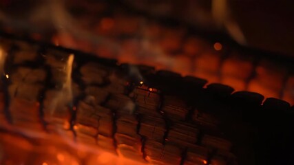 Sticker - a macro shot captures delicate sparks jumping from a slowly burning log, in shallow depth of field m
