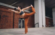 © BullRun - Woman performing dancer yoga pose outdoors, holding foot behind while extending arm. Conceptual wellness photo symbolizing empowerment, mindfulness, resilience, strength, and digital lifestyle.