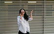 © BullRun - Joyful woman on phone call gestures with hands, expressing excitement. Conceptual portrait symbolizing digital communication, empowerment, individuality, and online connection in modern society.