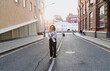 © BullRun - Woman walking alone on empty city street in casual outfit. Conceptual stock photo symbolizing independence, individuality, resilience, empowerment, and confident urban lifestyle identity.