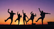 © Polina - Friends dancing energetically in silhouette on a rooftop at sunset