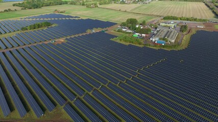 Aerial drone footage of busy highway motorway road with traffic and solar panels, photovoltaic energy generation electricity sunlight near Leicester, United Kingdom