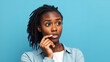© Colin - Photo of serious confused interested black millennial trying to remember important information biting her lips touching chin with hands isolated over blue color vivid background