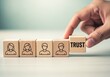 © Zander - Title: Inspirational business concept image of wooden blocks with team icons and a hand placing a TRUST block, ideal for corporate training, leadership workshops, or HR branding materials, symbolizing