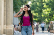 © Gonzalo Infiesta - Young woman walking city street listening music