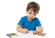 © okayon - Concentrated young boy creating colorful artwork with crayons on white surface