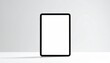 © Muhammad - Sleek digital tablet with a blank white screen standing vertically on a table, providing a clean mockup template for website or app display