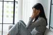 © Charlie's - Young Asian Woman Feeling Lonely Sad Sick Stressed on Sofa at Home Alone for Healthcare Wellness Lifestyle.