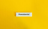 Powodzenia napis na białym kafelku na żółtym tle