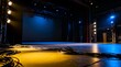 © Lazuardi - Empty theatrical stage illuminated by vibrant blue and yellow spotlights with cables in the foreground before a performance