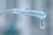 © Kanishka - Close-up of a clear IV tube with a drop of liquid forming at the tip, symbolizing precision, sterility, and life-saving care in a medical setting.