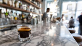 Caffè Corretto espresso on a marble café counter with blurred bartender in background