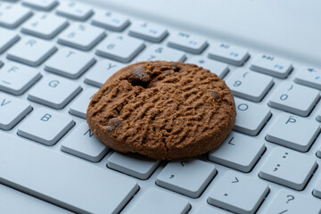 Wall Mural - Close-up of a cookie on a computer keyboard. Internet cookies, technology, and online privacy concepts.