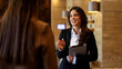 © PeopleVideos - Businesswoman talking with colleague, holding digital tablet in modern office or hotel lobby, smiling during discussion