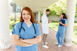 © StockMe - Confident nurse smiling, wearing scrubs and stethoscope, medical team colleagues working in hospital corridor