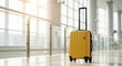 © ibnu - Yellow rolling suitcase with extended handle at airport ready for flight departure and travel journey.