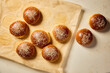© Melica - Freshly baked brioche buns with sesame seeds on baking paper. Golden homemade burger buns cooling after baking.