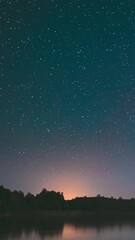 Wall Mural - Lyepyel District, Vitebsk Province, Belarus. Real Colorful Night Stars Above Lepel Lake. Natural Starry Sky Background Backdrop Landscape. Time lapse.