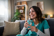 © Migma_Agency - Female healthcare worker relaxing at home drinking water