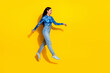 © deagreez - Young Woman in Blue Top Posing Joyfully Against a Bright Yellow Background for a Fashion Lifestyle Concept