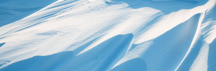 Wall Mural - Snow texture. Wind sculpted patterns on snow surface. Wind in the tundra and in the mountains on the surface of the snow sculpts patterns and ridges. Arctic, Polar region. Winter panoramic background.