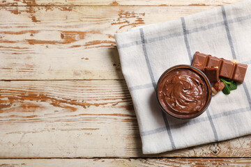Wall Mural - Glass bowl of sweet chocolate spread with hazelnuts and mint on white wooden background
