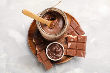 Wall Mural - Plate with bowl and jar of tasty chocolate spread on grunge background