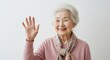 © momoka - 優しく手を振る笑顔のシニア女性 明るく清潔感のある背景が温かい雰囲気を演出. AI Generated