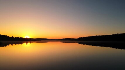 Wall Mural - stunning timelapse of a golden sunrise over a calm, pristine lake, with reflections and a peaceful, 
