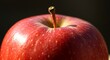© brogan - Close up of a ripe red apple with stem and subtle variations in texture