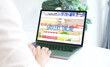 © mangpor2004 - Hand using laptop computer with grocery online shopping over blur supermarket on screen background, business and technology, lifestyle concept