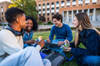 © unai - Diverse university students laughing, eating lunch on campus