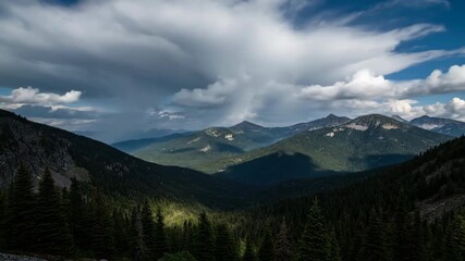 Wall Mural - dramatic clouds and moving shadows sweep across a vast mountain forest landscape in an epic timelaps