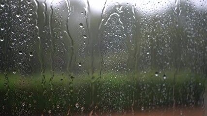 Wall Mural - ﻿Timelapse of rain falling and streaming down a windowpane, creating abstract patterns storm, calm, texture