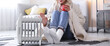 © New Africa - Young woman with cup of drink near electric heater on floor at home, closeup