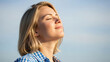 © flowstd - Woman enjoying fresh air with eyes closed in sunlight.