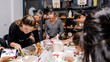 © HI Pictures - In an art studio during a group art event, a group of women and children are enjoying a creative hobby, learning and having fun as they make shapes out of clay