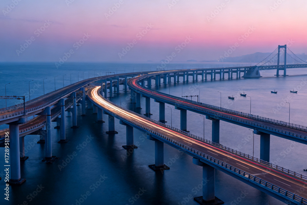 Long exposure view of a curved bridge over water at twilight with light ...