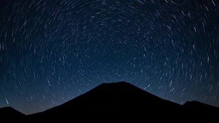 Wall Mural - The celestial dance of stars rotates above a dark volcanic silhouette under a clear night sky, presented as a mesmerizing astro timelapse meditation, peaceful, magical