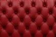© MetaPixel - Detailed texture of deep red capitone leather upholstery with vintage Chesterfield-inspired tufted design and diamond buttons