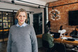 © Maskot - Portrait of smiling senior female business professional wearing sweater at office